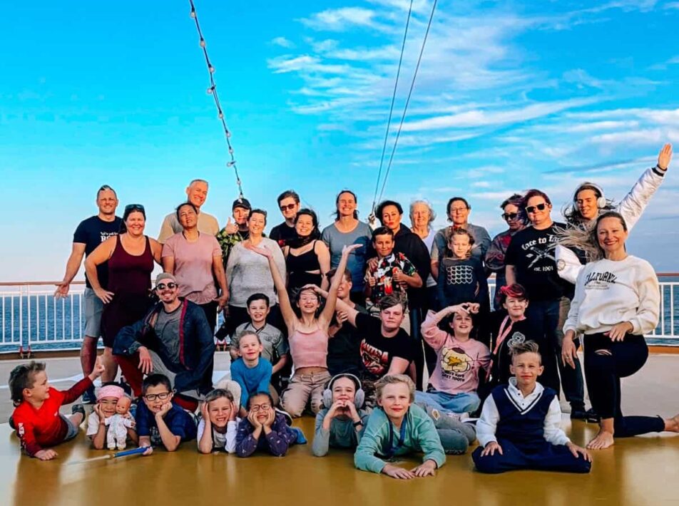 Group of worldschooling families at sunset on deck