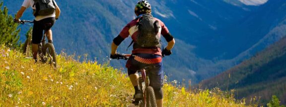 cyclists-mountain-biking-hillside-terrain-gtk73hosxj3e5xcp